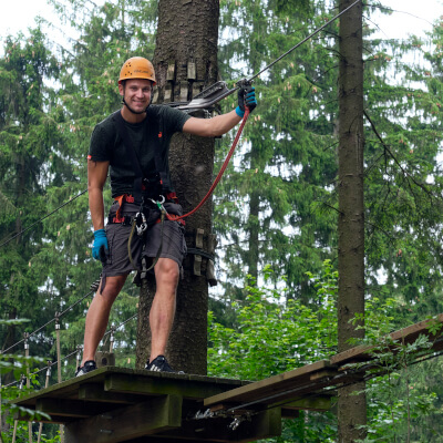 Junger Mann klettert im Hochseilgarten